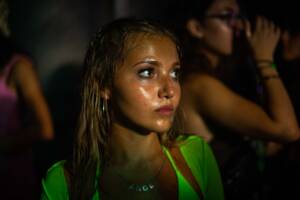 A young girl in a night club looking pensively into the distance.